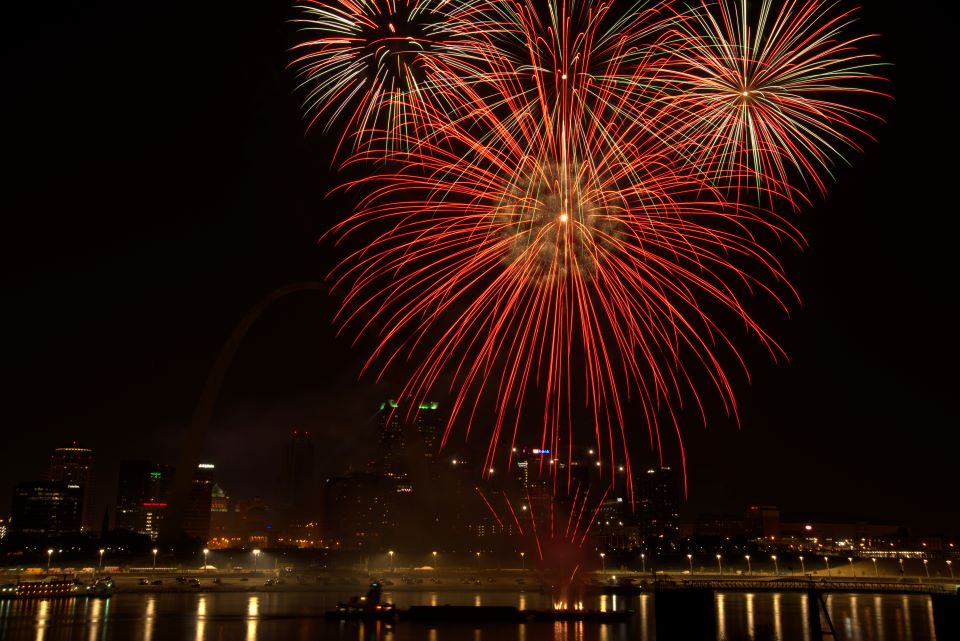 Fireworks explode over the Mississippi River at night in down St. Louis. The skyline is in the background.
