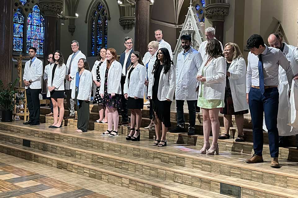 A group of new pro School of Medicine students receive their white coats. 